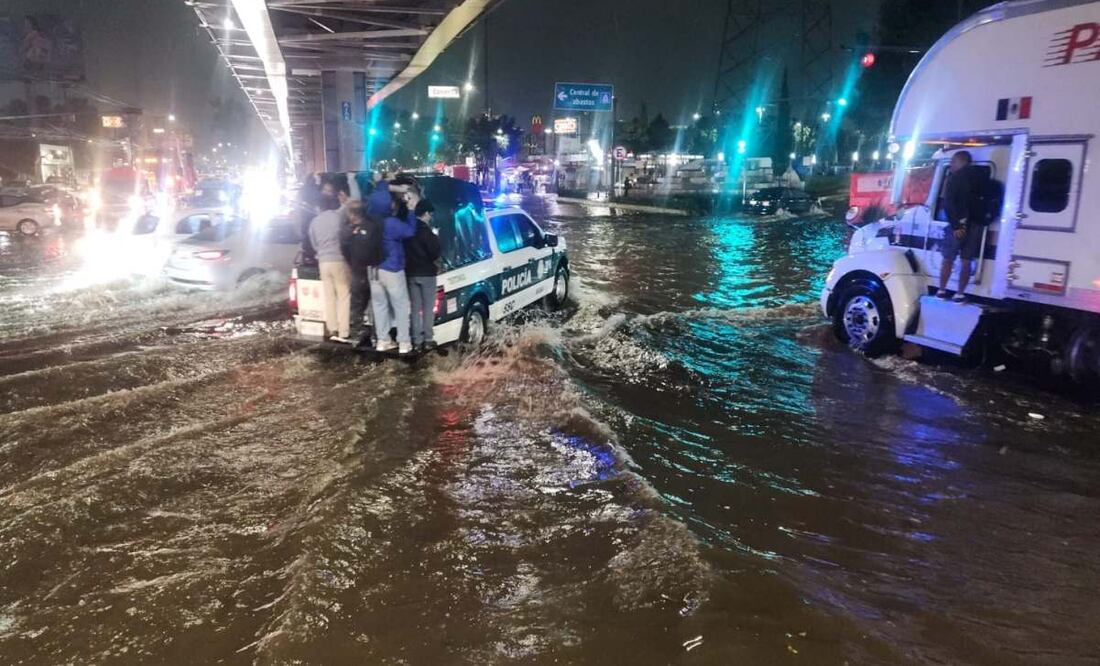 Policías ayudan en el traslado de personas por inundaciones. Foto: Especial.