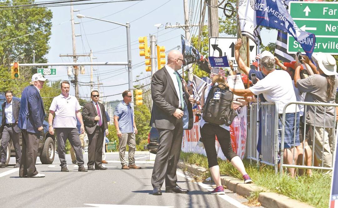 Donald Trump saludó ayer a sus seguidores tras abandonar el Trump National Golf Club, en Nueva Jersey. Foto: NICHOLAS KAMM. AFP