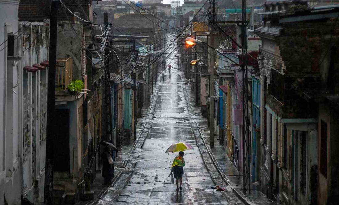 Una mujer camina por una calle antes de que el huracán "Melissa" azote la ciudad de Santiago de Cuba, Cuba, el 28 de octubre de 2025. Foto: AFP
