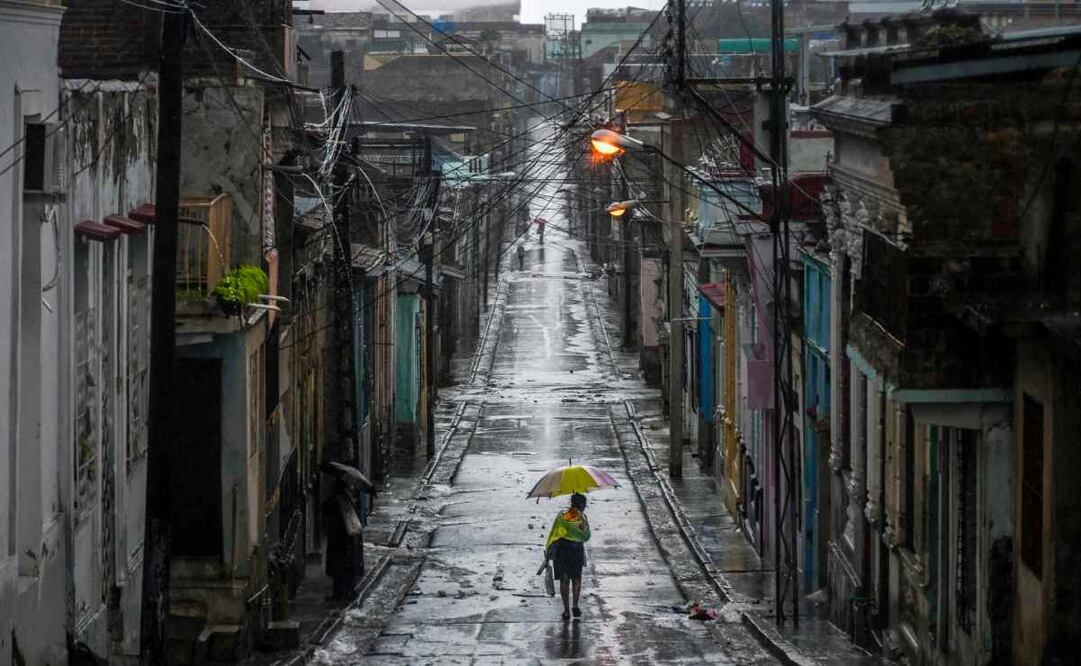 Una mujer camina por una calle antes de que el huracán "Melissa" azote la ciudad de Santiago de Cuba, Cuba, el 28 de octubre de 2025. Foto: AFP