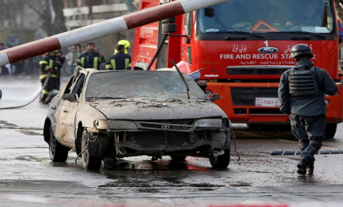 Police officers keep watch while a man drives his heavily damaged car at a car bomb attack site in Kabul Afghanistan – Photo: Omar Sobhani/REUTERS