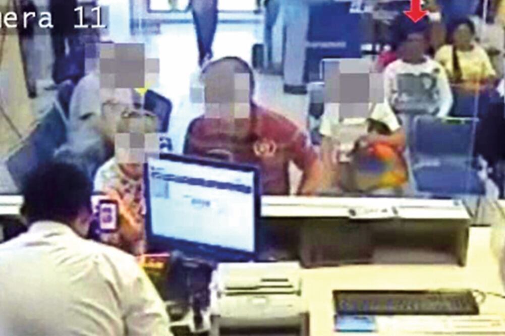 En el video otorgado por la sucursal bancaria se ve a uno de los detenidos cómo observa las transacciones en ventanilla (ESPECIAL)