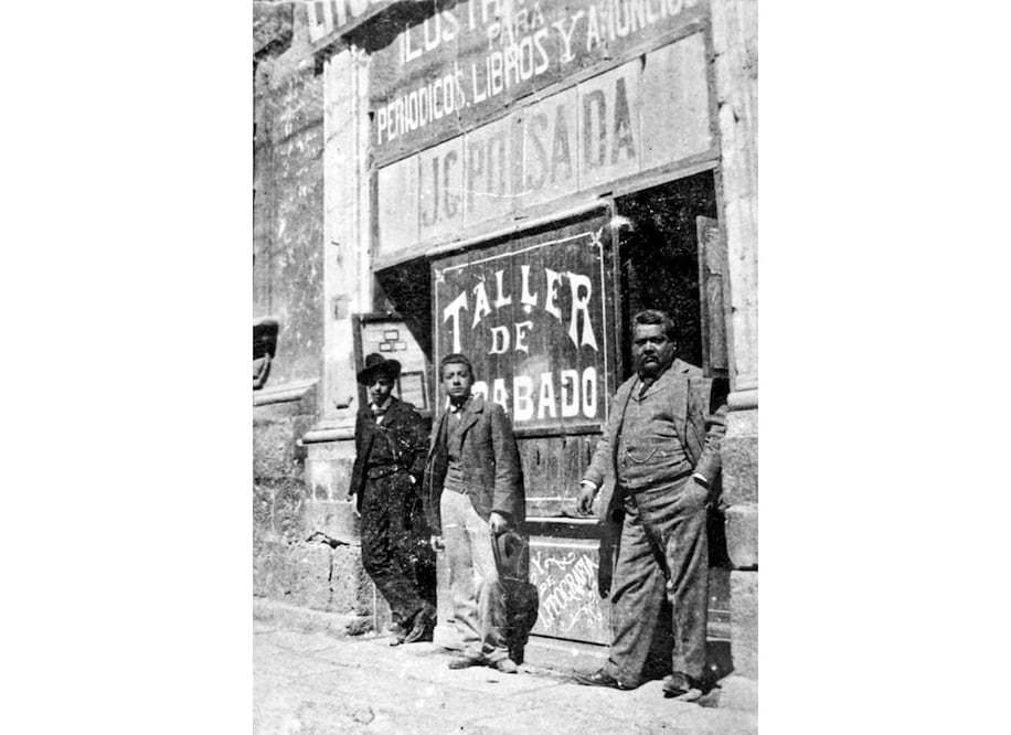 Pegado a la derecha, José Guadalupe Posada en la puerta de su taller de grabado. Foto: Archivo Casasola