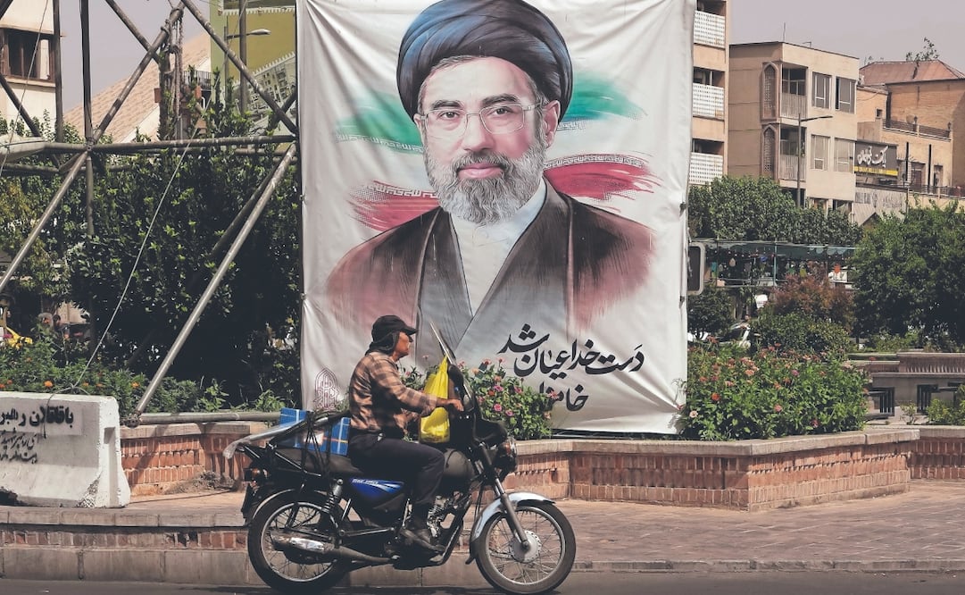 Un motociclista pasa junto a un retrato del ayatola Mojtaba Jamenei, en Teherán. Foto: Vahid Salemi/ AP