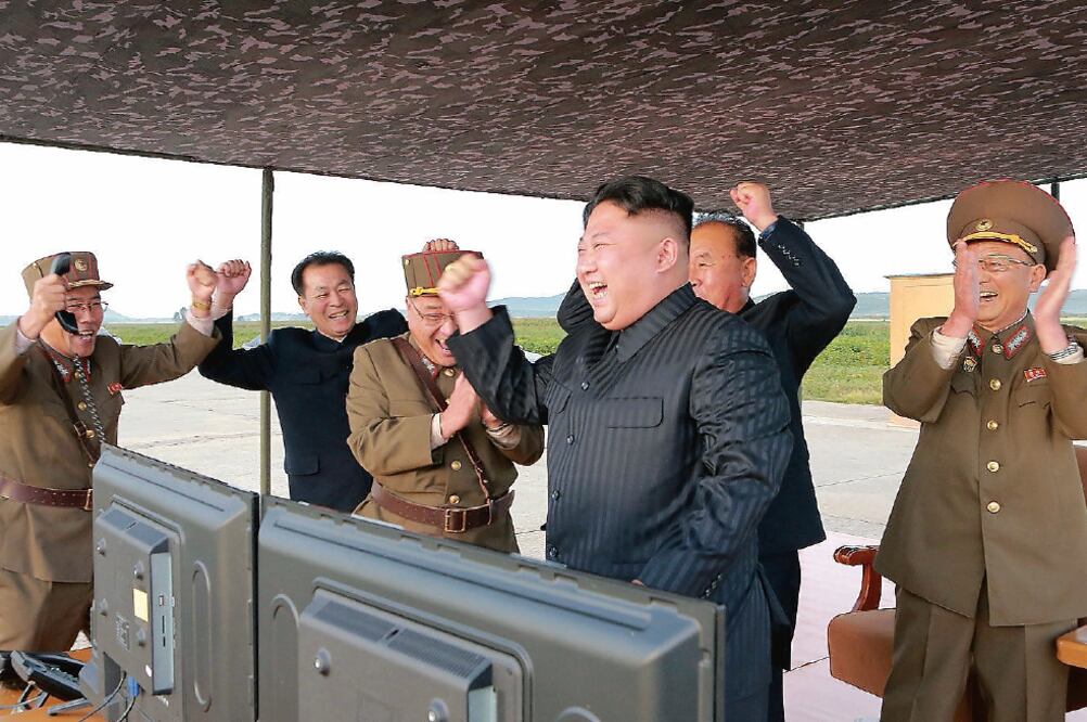 El líder norcoreano, Kim Jong-un, celebra con militares el lanzamiento de un misil Hwasong-12, en esta foto proporcionada por la agencia oficial KCNA. (REUTERS)