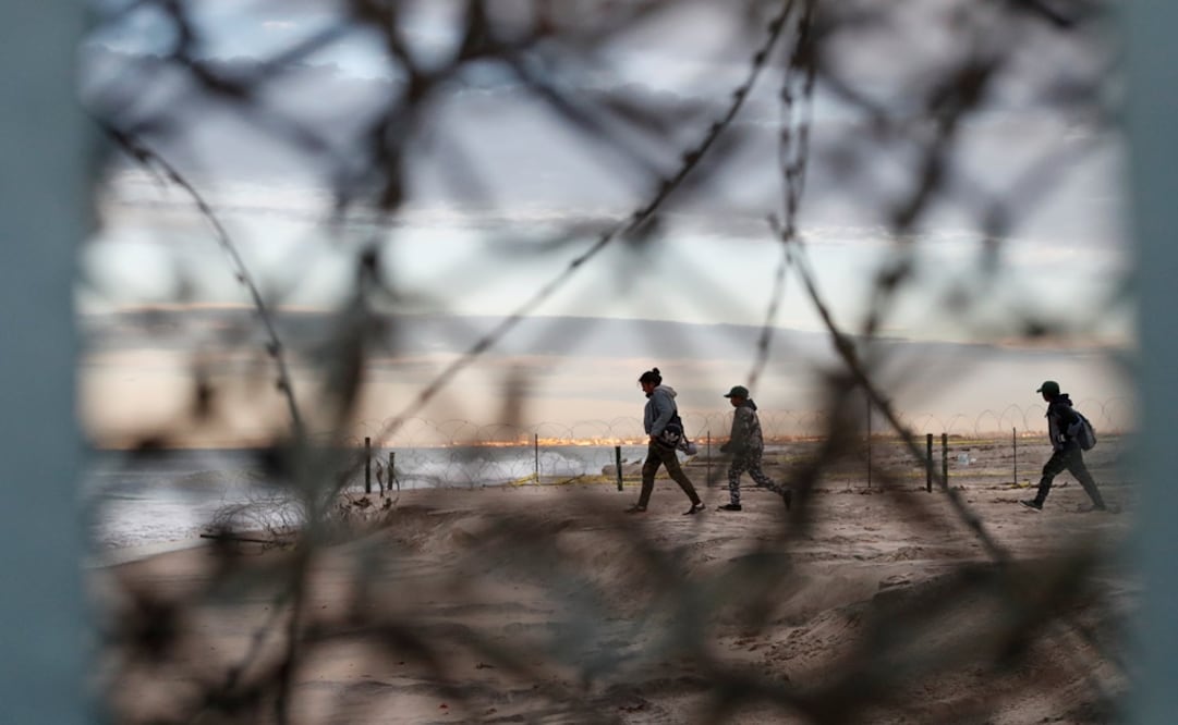 A migrant woman and two boys walk close to concertina wire after crossing illegally from Mexico to the U.S, as seen from Tijuana, Mexico - Photo: Carlos Garcia Rawlins/REUTERS