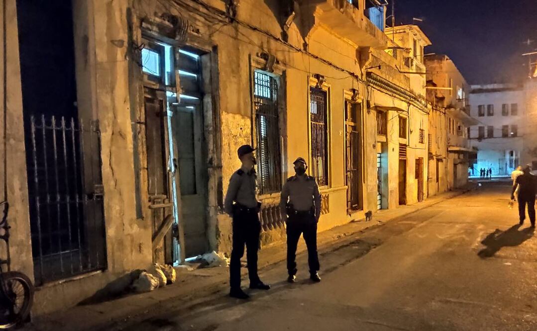Dos policías permanecen afuera de la casa donde se encontraban los disidentes en huelga de hambre y sed hoy, en la barriada de San Isidro, en La Habana. Foto: EFE
