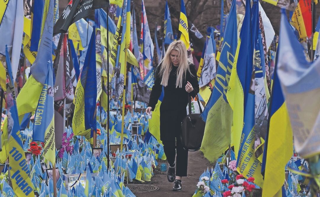 Una ucraniana visita un monumento improvisado en memoria de los combatientes caídos en la Plaza de la Independencia de Kiev. Foto: de GENYA SAVILOV. AFP