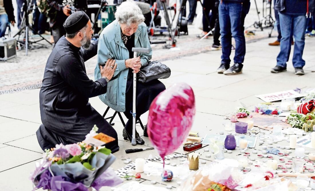 Sadiq Patel, musulmán, consuela a Renee Rachel Black, judía, junto a un memorial en homenaje a las víctimas del atentado (DARREN STAPLES. REUTERS)