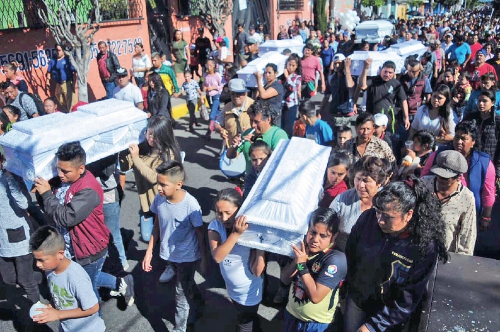 Decenas de personas se unieron a la procesión de los siete ataúdes de Diego y Óscar, de dos años, Jimena, de cuatro, Adriana, de seis, Marlene, de nueve, Cruz Hidalgo y Miguel Ángel, de 13 años, en su camino al panteón de Santa Cruz. Foto: DIEGO SIMÓN.