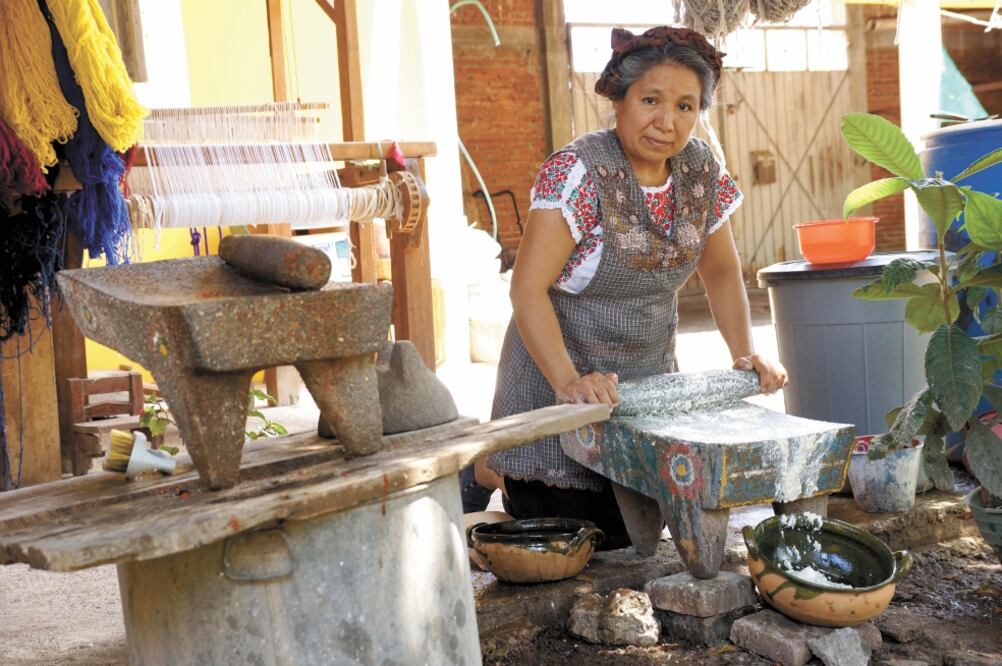 Por generaciones, las mujeres de Teotitlán, como Laura Ruiz Jiménez, han conservado técnicas tradicionales de la cocina zapoteca, como la molienda. Fotos: EDWIN HERNÁNDEZ