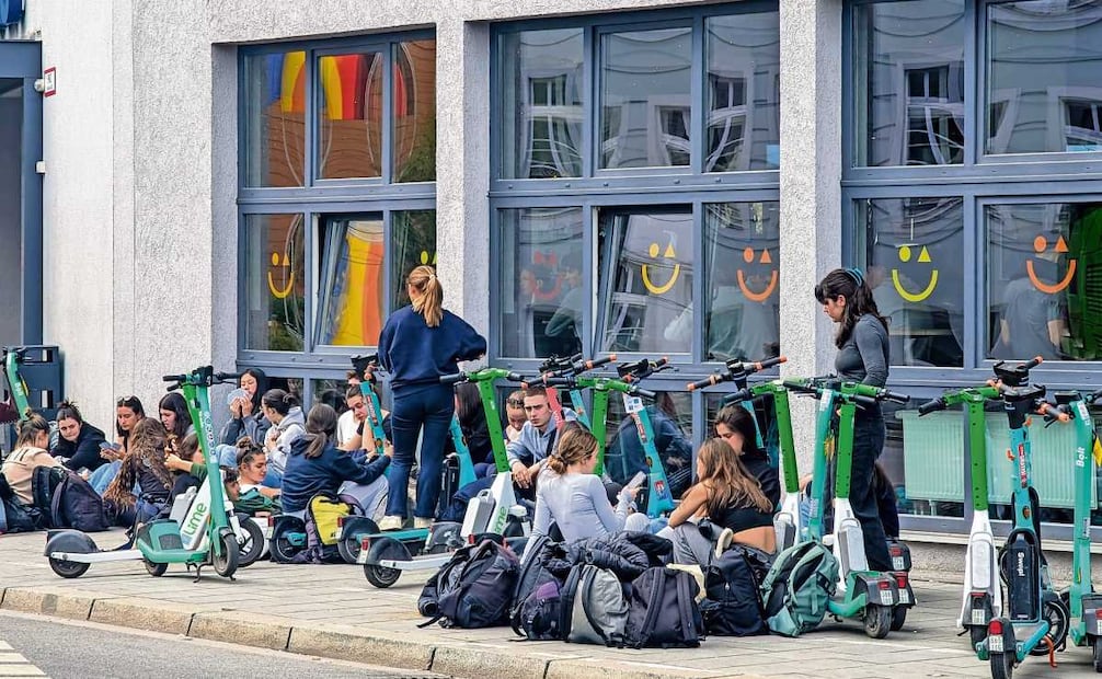 Jóvenes turistas, frente al a&o Hostel München Hackerbrücke, con filas de
scooters de alquiler alineados en Múnich, Alta Baviera, Alemania. Foto: MICHAEL NGUYEN/AFP