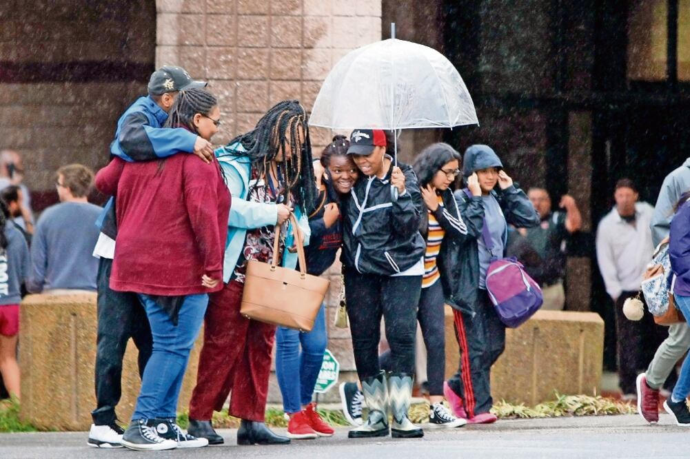 Angustia. Jóvenes y sus padres se abrazan afuera de la secundaria Dalton, en Georgia, luego de un incidente en el que un profesor se atrincheró, armado y solo, en un salón, y disparó sin herir a nadie. (AP)