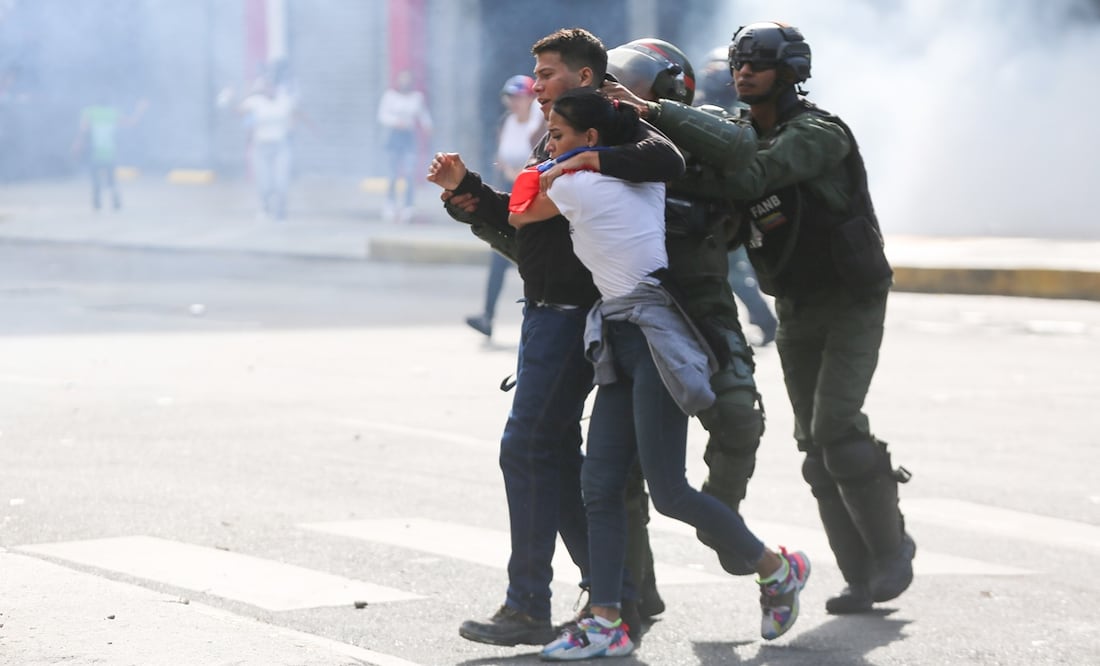 Integrantes de la Guardia Nacional detienen a personas durante una protesta por los resultados de las elecciones presidenciales en Venezuela. Cientos de personas se manifiestan en Caracas luego de que el Consejo Nacional Electoral (CNE) proclamara a Nicolás Maduro como presidente reelecto de Venezuela. Foto: EFE/ Manuel Díaz
