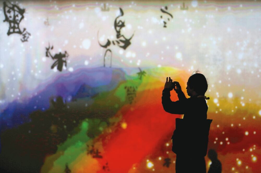 Una mujer toma una foto a la instalación digital “Qué mundo tan amoroso y hermoso”, realizada para la cumbre del G7 que arranca hoy en la prefectura de Ise-Shima, en Japón (TORU HANAI. REUTERS)