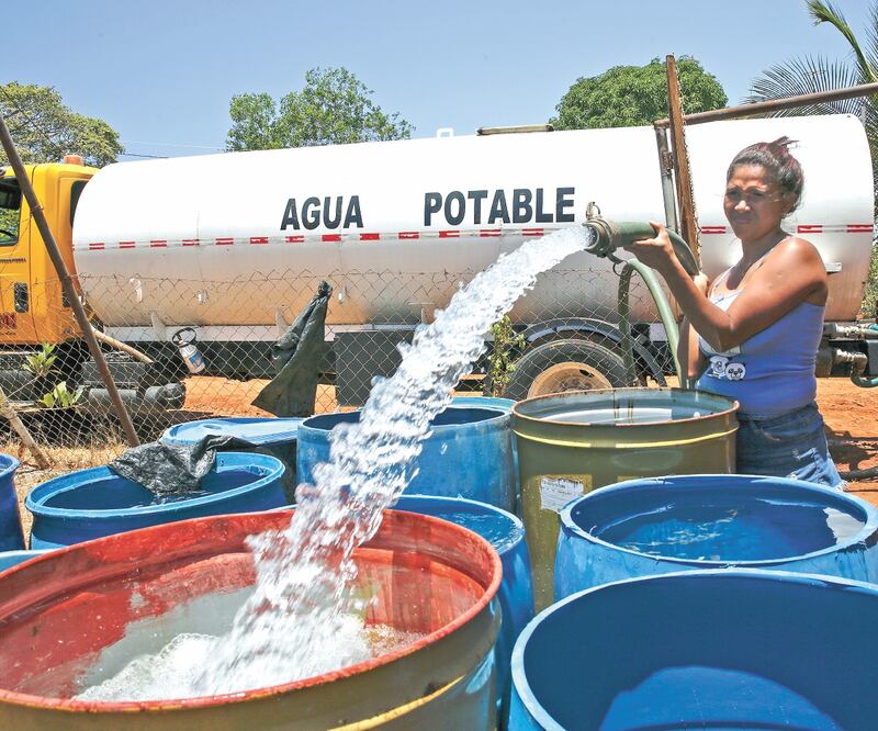 Una mujer llena botes de agua en Panamá. Según estudios, en 2025, 2 mil millones de personas vivirán en lugares donde la falta del líquido será total. Foto: ARNULFO FRANCO. AP