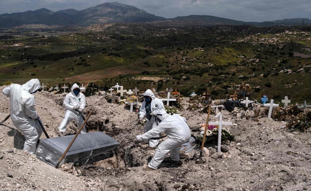Cemetery workers wear protective gear as they bury an unclaimed Covid-19 coronavirus victim, at the Municipal Cemetery No. 13 in Tijuana, Baja California - Photo: Guillermo Arias/AFP