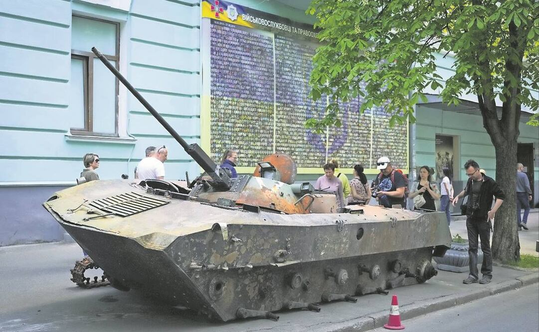 Ucranianos, cerca de un blindado ruso destruido en Kiev. Foto: EFREM LUKATSKY/AP