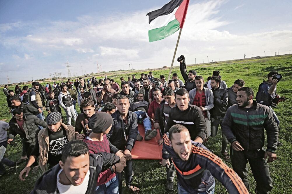 Manifestantes palestinos trasladaron ayer a uno de los herido durante enfrentamientos con tropas israelíes en la Franja de Gaza (MOHAMMED SABER. EFE)