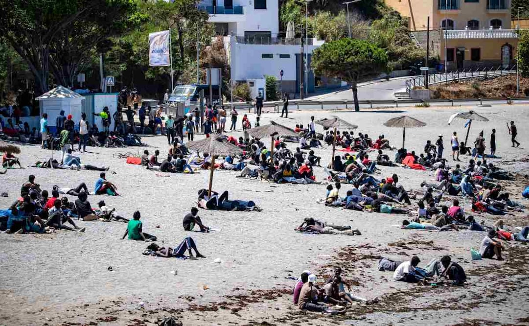 Migrantes que irrumpieron en España desde Marruecos se reúnen en una playa del enclave español de Ceuta, el domingo 2 de agosto de 2026. Foto: AP