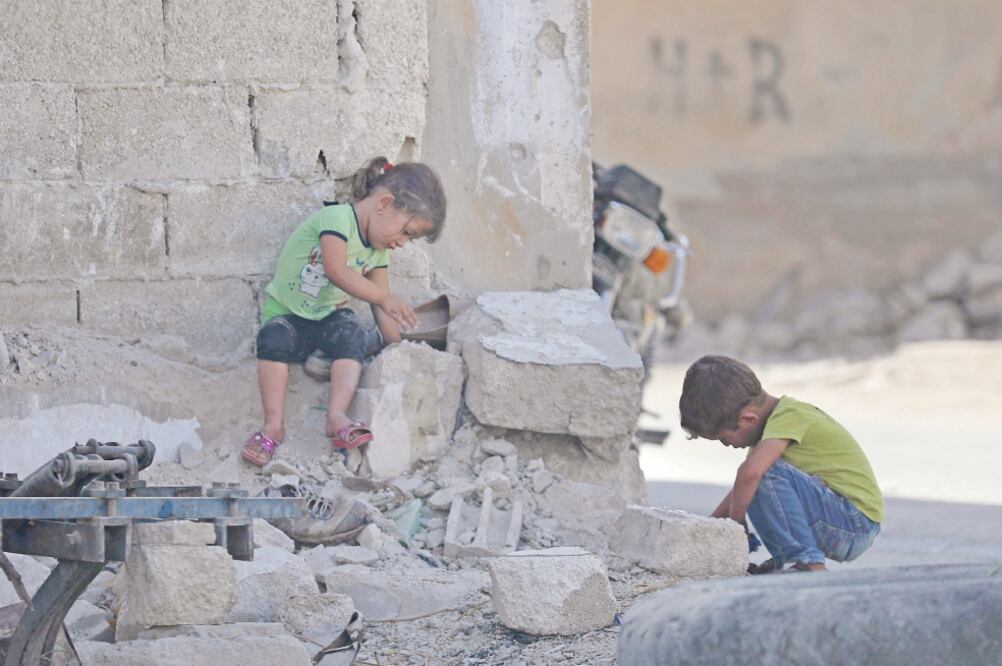 Dos niños juegan en Morek, en la provincia siria de Hama, que limita con la provincia rebelde de Idlib. Foto: OMAR HAJ KADOUR. AFP