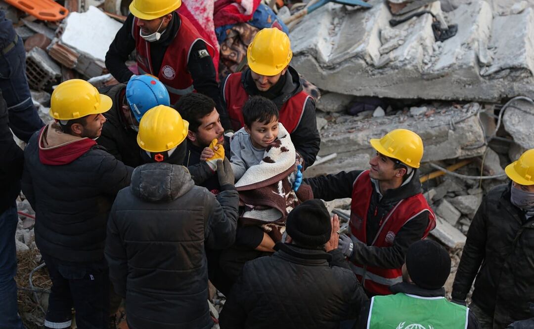 Un pequeño y sus padres fueron rescatados de un edificio colapsado en Hatay, Turquía. Foto: EFE