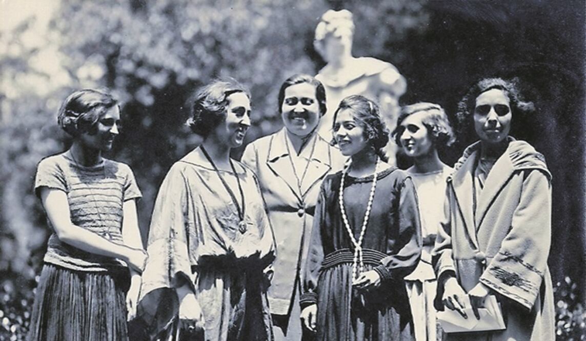 Gabriela Mistral (atrás, al centro) rodeada de un grupo de jóvenes sin identificar.
