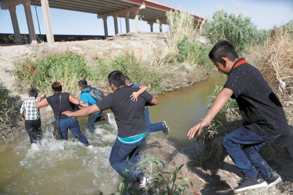 Migrantes corren para atravesar el río Bravo y entregarse, del lado estadounidense, a las autoridades migratorias de El Paso. Foto: CHRISTIAN TORRES. AP