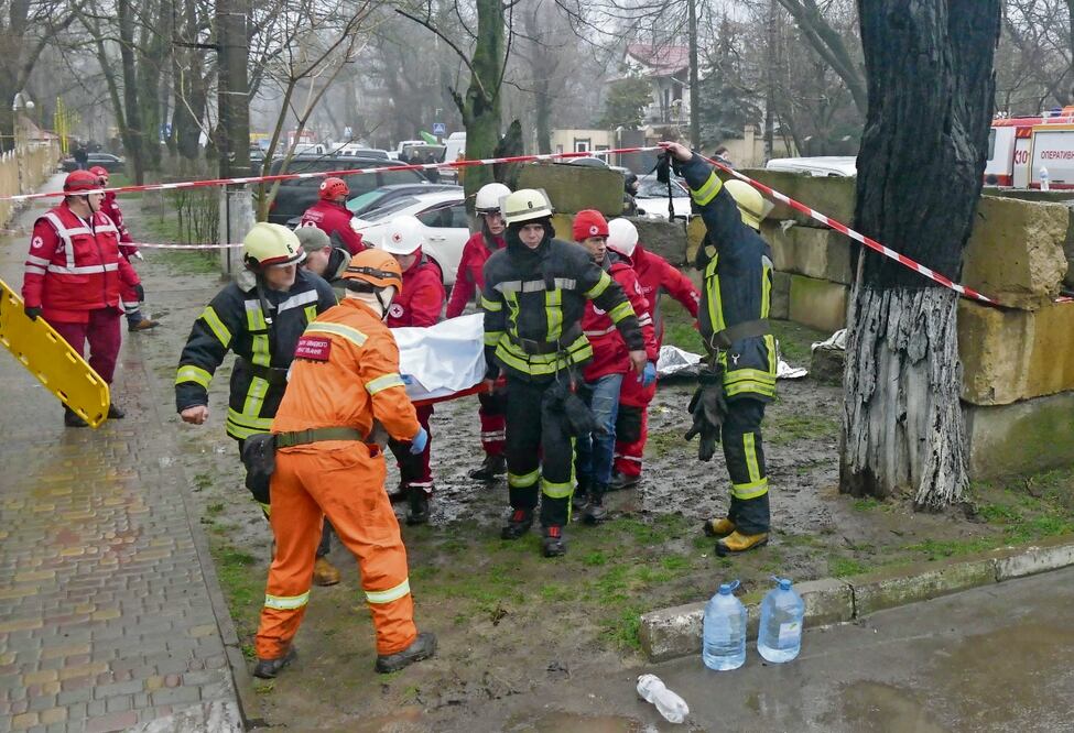 Los rescatistas ucranianos llevan el cuerpo de un colega muerto cerca del lugar de un bombardeo en Odesa. Foto: Igor Tkachenko | EFE