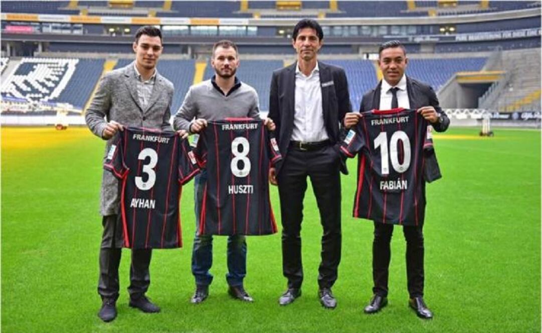 The Mexican player showed his new shirt at the Commerzbank Arena accompanied by Kaan Ayhan and Szabolcs Huszti, new sign-ups of the red eagles.   (Photo: Eintracht Frankfurt) 