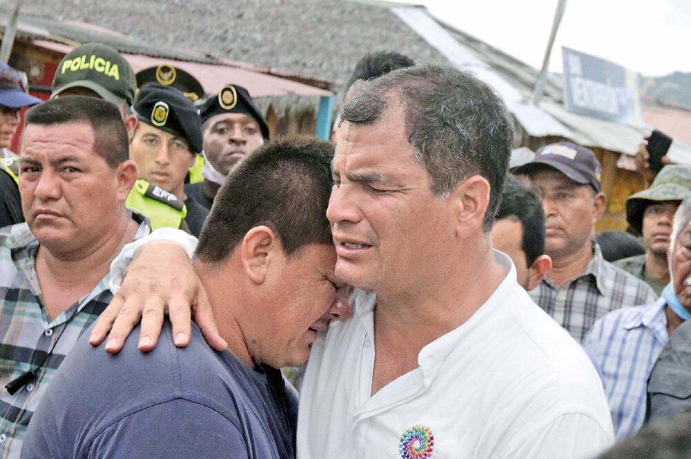 El mandatario ecuatoriano, Rafael Correa (derecha), abraza a un damnificado del terremoto del 16 de abril, al visitar la zona, hace unos días (HENRY ROMERO. REUTERS)