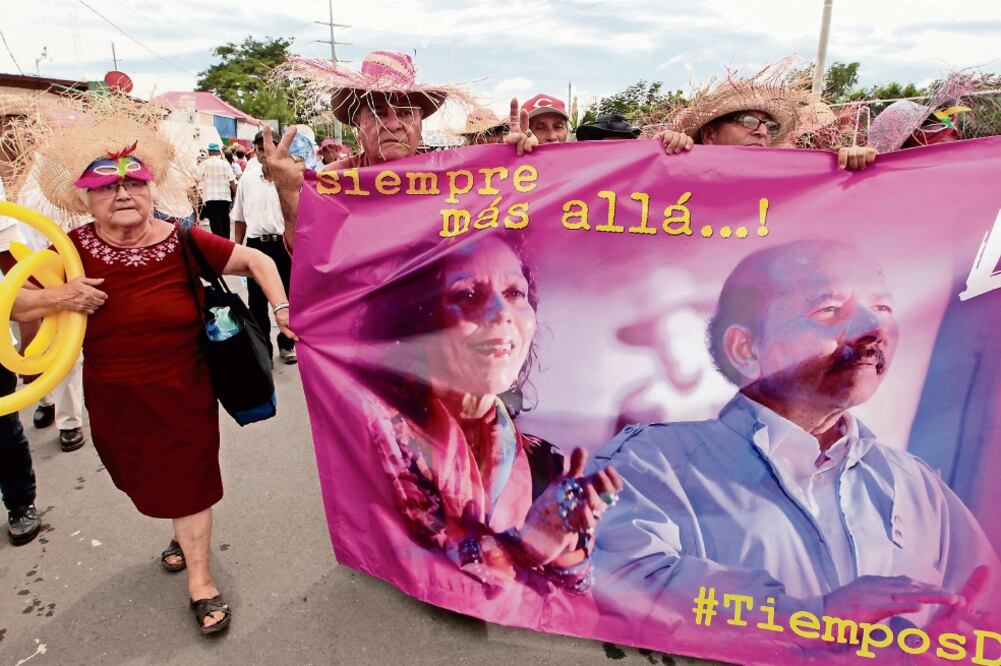 Adultos mayores con una pancarta en apoyo de la fórmula Ortega-Murillo, en un acto el 12 de octubre, en Managua (OSWALDO RIVAS. REUTERS)