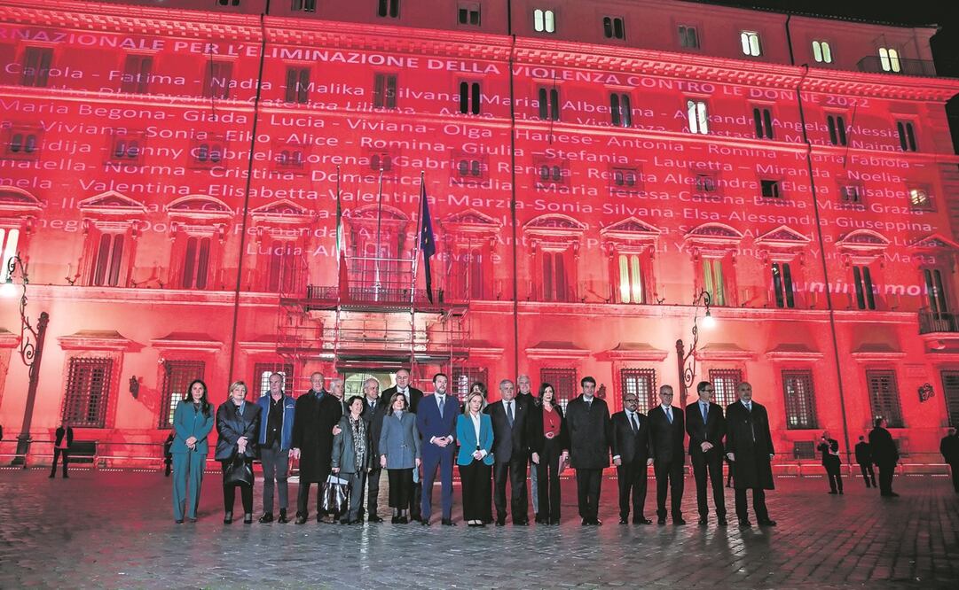 La premier de Italia, Giorgia Meloni (centro), y otros funcionarios frente a la sede del gobierno, que proyectó los nombres de 104 mujeres asesinadas en este 2022. Foto: EFE