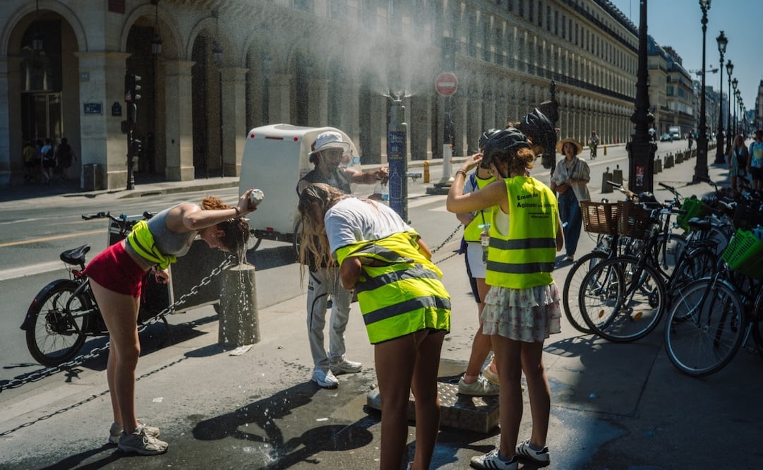Los turistas intentan refrescarse en el punto de agua cerca del museo del Louvre en el centro de París, el 1 de julio de 2025, ya que se espera que las temperaturas en Francia alcancen un pico hoy, según la agencia meteorológica Meteo France. Foto: AFP