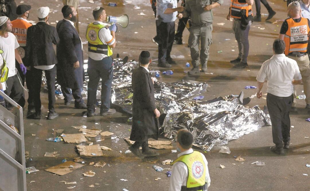 Judíos ultraortodoxos y rescatistas junto a los cuerpos de víctimas de la estampida, en Merón. Foto: David Cohen. AFP