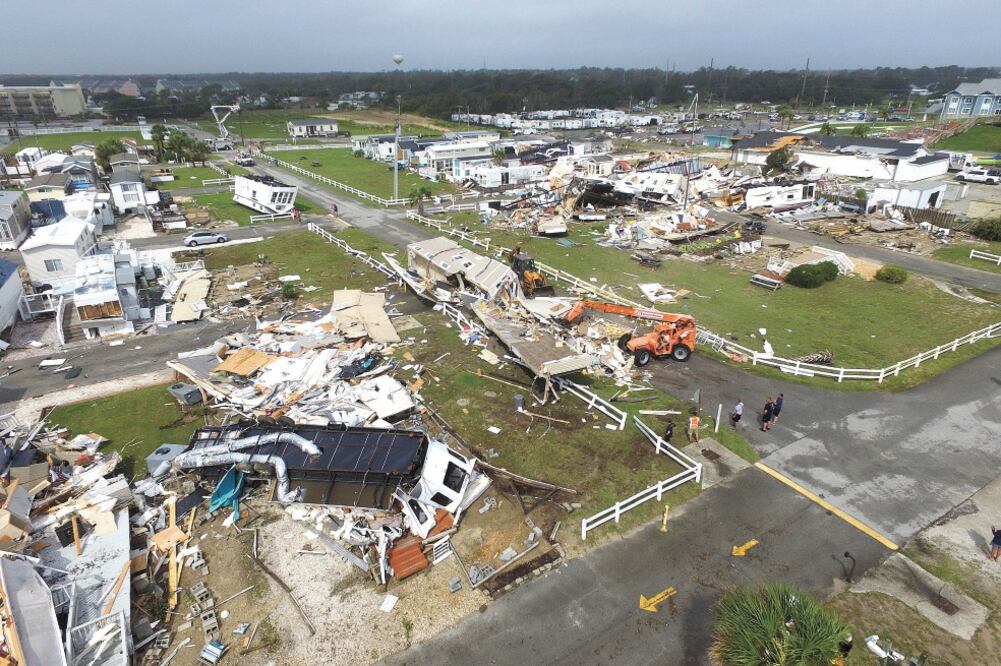 Empleados de Emerald Isle, en Carolina del Norte, limpian el camino luego de que un tornado, ocasionado por Dorian, dejara destrozos en la zona. Foto: TOM COPELAND. AP