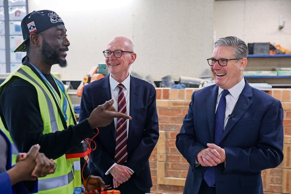 El premier británico, Keir Starmer (der.), ayer con un aprendiz de construcción en Londres. Foto: Toby Melville / AP