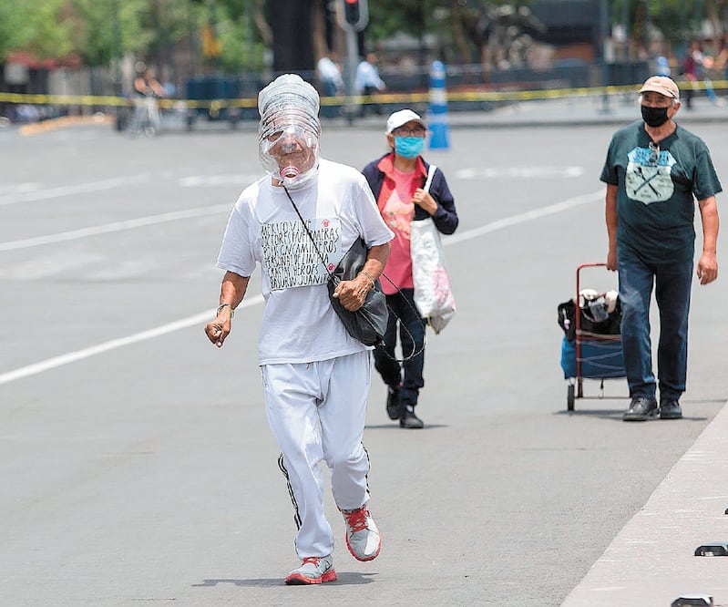 Un hombre trota alrededor de la Plaza de la Constitución, en Ciudad de México, con una botella en la cabeza. MOISÉS PABLO. CUARTOSCURO