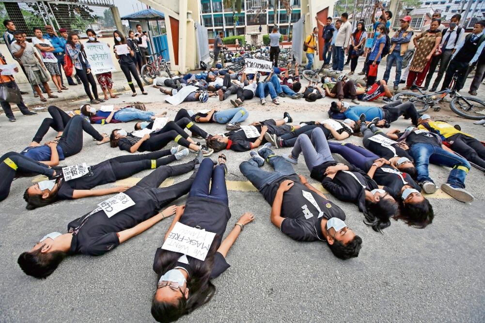 Nepaleses durante su participación, el domingo pasado, en una manifestación por el Día Mundial del Medio Ambiente. Los jóvenes se pusieron máscaras anticontaminación y portaron carteles que decían “M a skmandu”, por Kathmandú (NARENDRA SHRESTHA. EFE)
