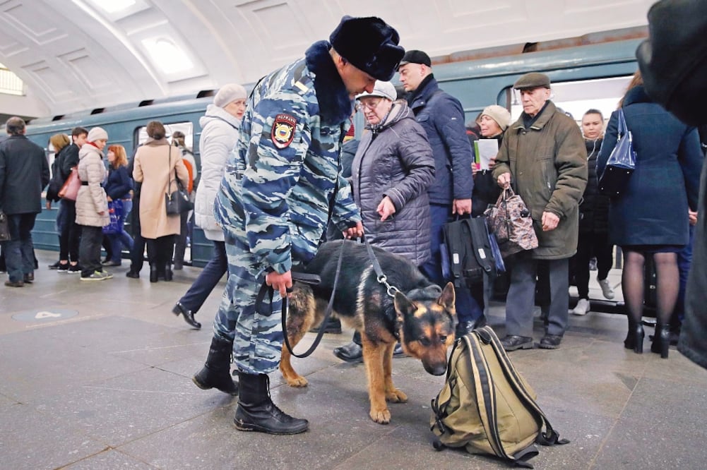 Un policía ruso y su perro registraban ayer una mochila en una estación del Metro en Moscú, tras el atentado del lunes contra el Metro en San Petersburgo (YURI KOCHETKOV. EFE)