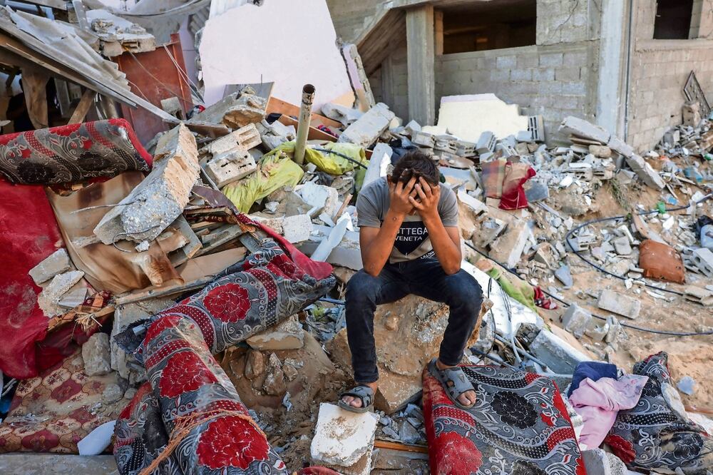 Un joven palestino reacciona sentado en las ruinas de lo que alguna vez fue su hogar, luego de la contraofensiva israeli en Rafá, al sur de la Franja de Gaza. Foto: Mohammed Abed | AFP