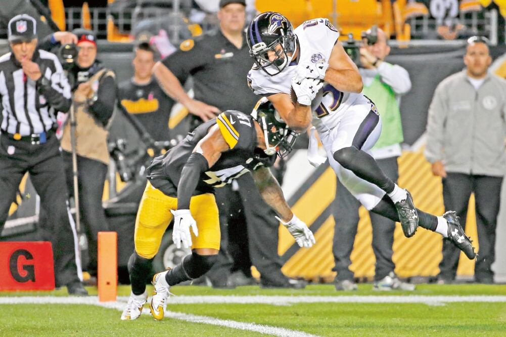 El receptor Michael Campanaro logra un touchdown tras deshacerse de la marca del esquinero de los Steelers, Antwon Blake (GENE J. PUSKAR. AP)