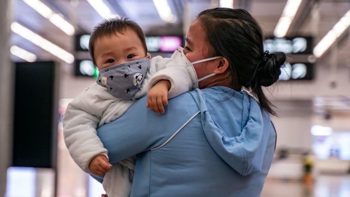 Una mujer lleva a un bebé con una máscara protectora en Hong Kong, donde desde el próximo sábado todos los visitantes de China continental serán sometidos a una cuarentena obligatoria (Foto: Getty Images)
