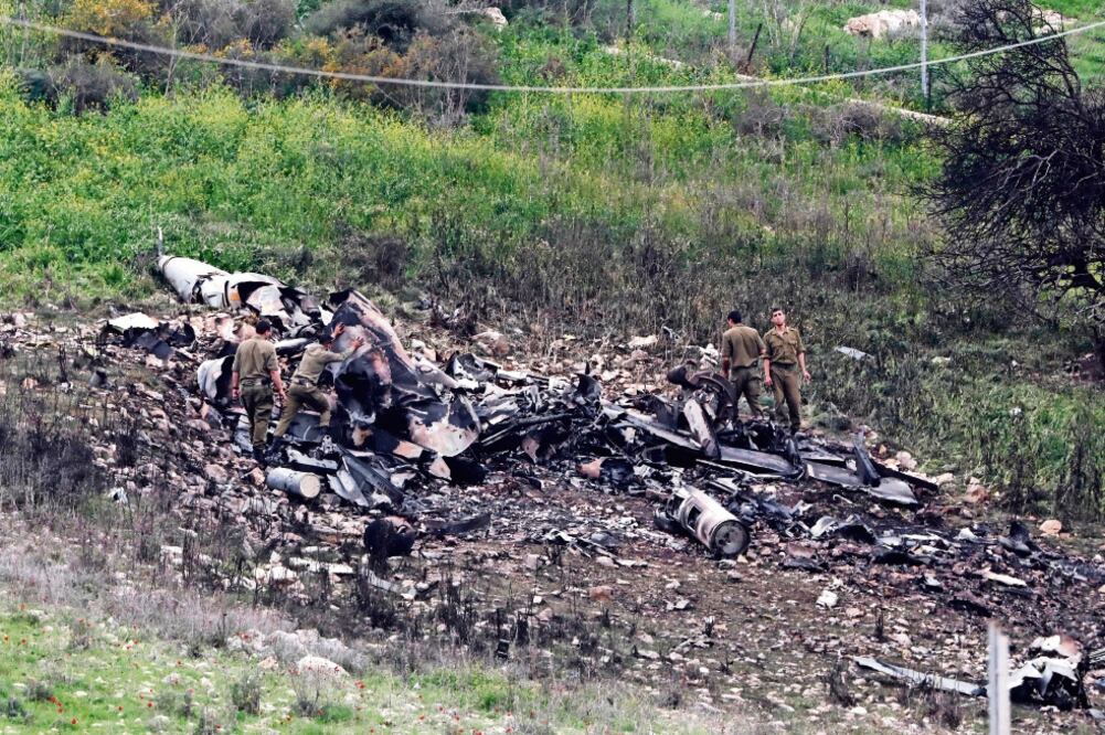 Crece tensión. Soldados israelíes inspeccionan los restos de su avión de combate F-16, derribado por la defensa siria. (ABIR SULTAN. EFE)