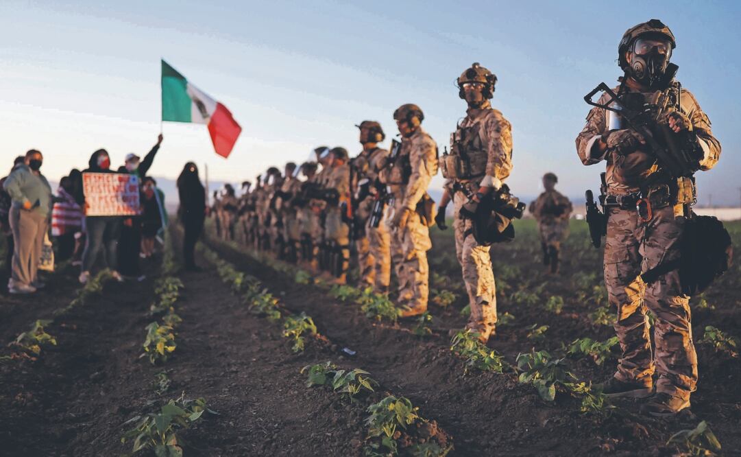 Agentes federales y miembros de la Guardia Nacional bloquean a personas que protestaban contra la redada del ICE en una granja de cannabis. Foto: de MARIO TAMA. AFP