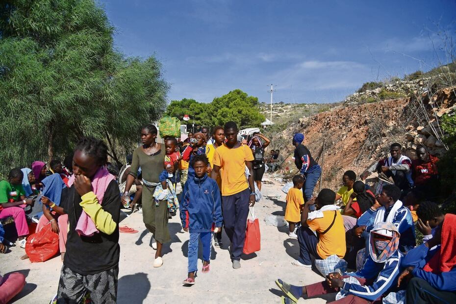 Migrantes, frente al centro operativo de recepción y redistribución de indocumentados en la isla de Lampedusa, el 14 de septiembre pasado. Foto: Alessandro Serrano | AFP