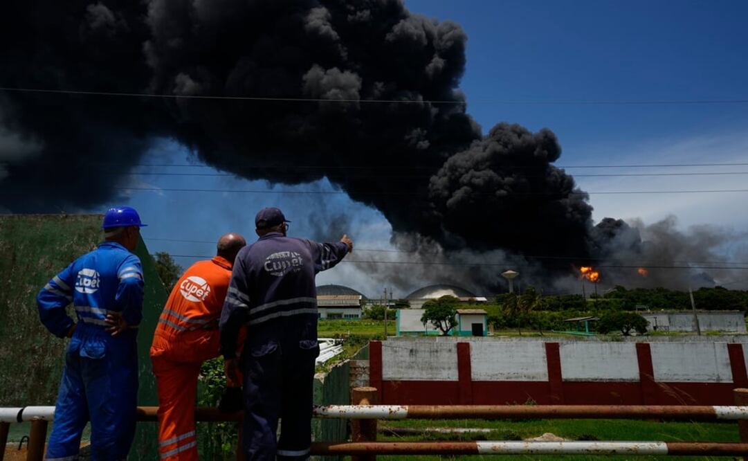 Los trabajadores del Sindicato Petrolero de Cuba, observan una enorme columna de humo que se eleva desde la Base de Superpetroleros de Matanzas. Foto: AP 