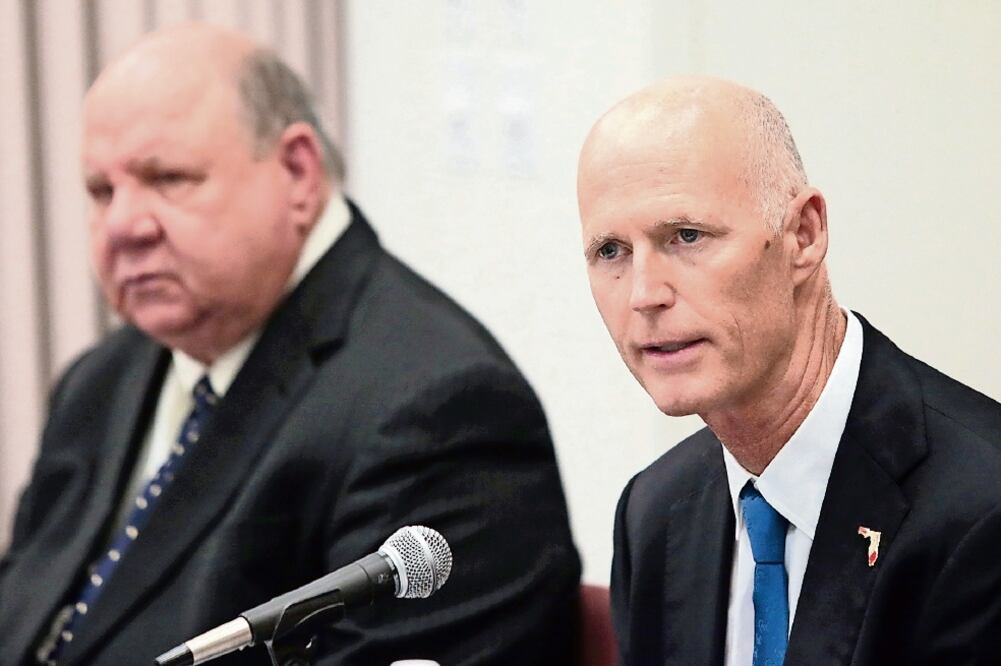 Rick Scott, gobernador de Florida (der.), se reunió ayer con autoridades loca les para discutir acciones contra el virus del zika en la zona (HEATHER LEIPHART. AP)