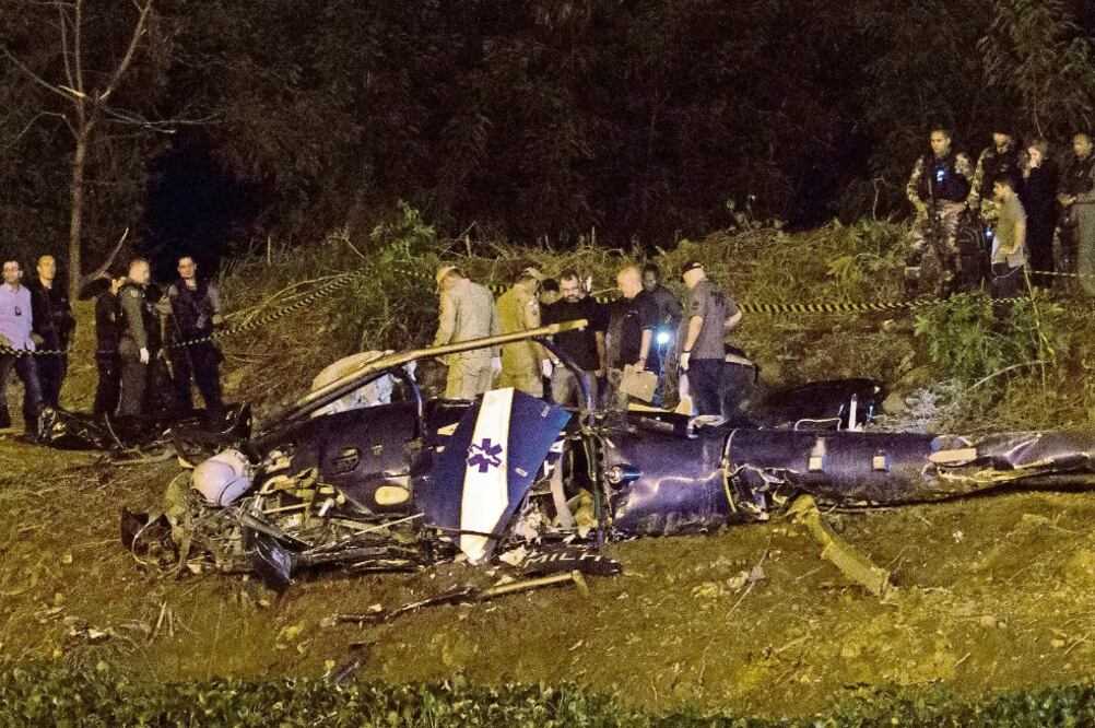 Revisión. La policía se reúne en el sitio donde se estrelló un helicóptero militar, en la favela Ciudad de Dios, durante una operación contra narcos. (FOTO: LEO CORREA. AP)