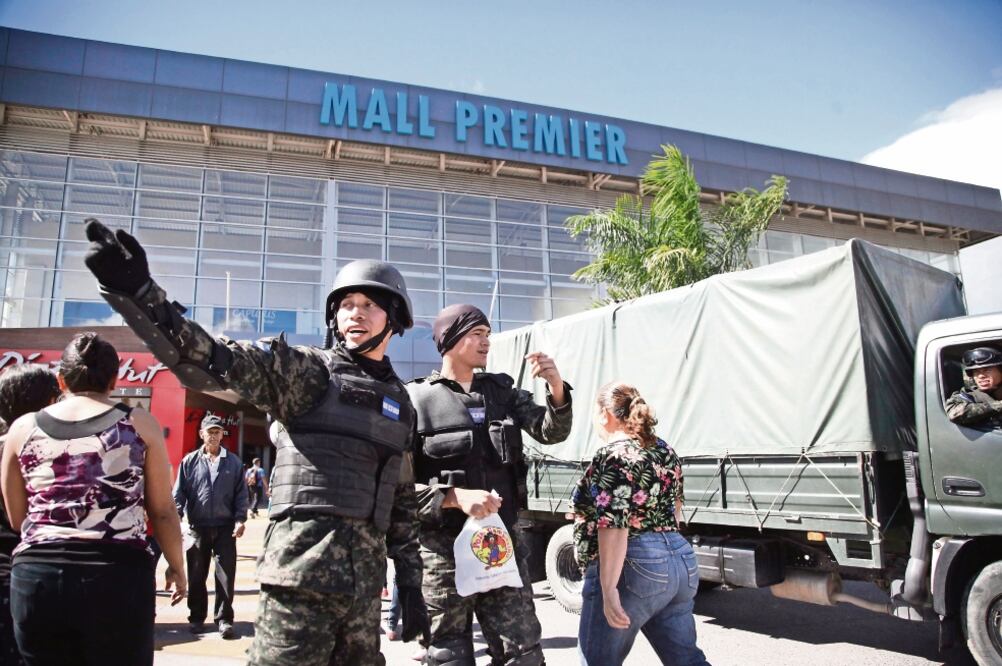 Soldados hicieron guardia afuera de un centro comercial, luego de que se registraran saqueos y enfrentamientos con manifestantes en Tegucigalpa. (FERNANDO ANTONIO. AP)